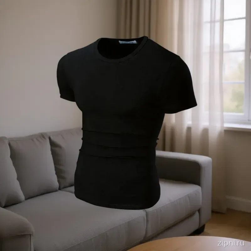 Футболка slim fit на мужчине, сидящем на сером диване в современной гостиной с большими окнами.